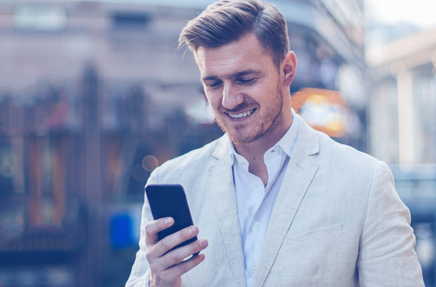Man smiling as he looks at mobile phone