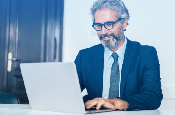 man with glasses using a laptop