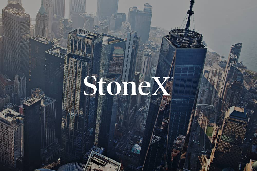Logotipo de StoneX sobre un fondo de ciudad